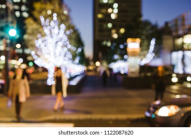 Pedestrians approach a crosswalk in Center City Philadelphia at night. The image is intentionally blurred.
