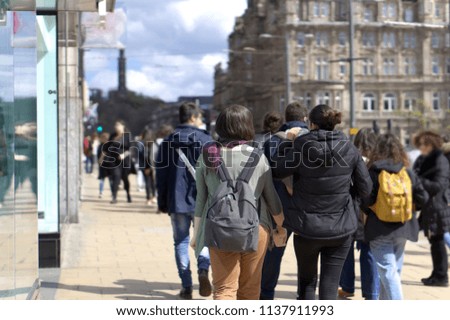 Pedestrians in casual dress on a busy shopping street in Edinburgh