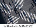 Pedestrians crossing the street at a busy intersection in Ginza, a popular upscale shopping area of Tokyo, Japan.