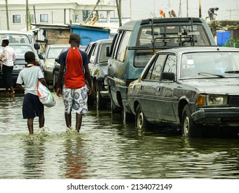 Pedestrians walking in the street flooded with water after a rainy week in Lagos, Nigeria. 