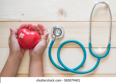 Pediatric care and child nursing healthcare service concept with kid patient's hands supporting red heart with medical stethoscope