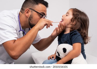 Pediatric Doctor Examining The Throat Of A 3 Year Old Girl