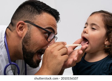 Pediatric Doctor Examining The Throat Of A 3 Year Old Girl