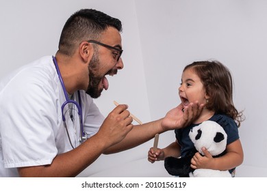 Pediatric Doctor Examining The Throat Of A 3 Year Old Girl