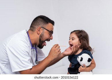 Pediatric Doctor Examining The Throat Of A 3 Year Old Girl