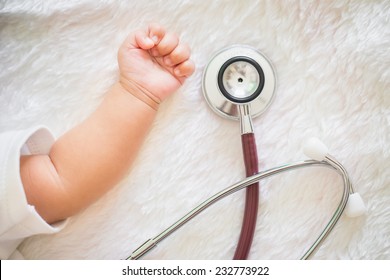Pediatric doctor exams little baby girl with stethoscope