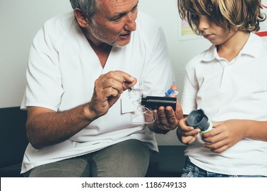 The Pediatric Endocrine Doctor Explaining To A Young Diabetic Patient The Insulin Pump Functions In His Office. Child Diabetes Concept