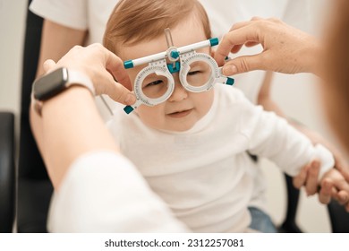 Pediatric eye doctor preparing child for visual acuity test