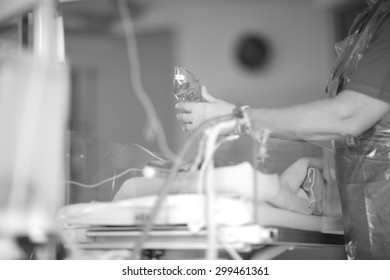 Pediatric Nurse With An Oxygen Mask In Hand Next To Baby Incubator