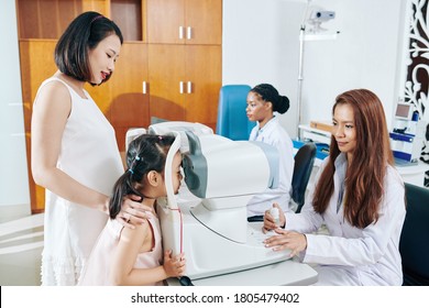 Pediatric Ophthalmologist Checking Oculus Fundus Of Little Girl Via Non-mydriatic Camera In Clinic