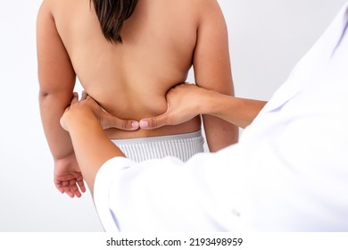 Pediatric Orthopedic Physiotherapist Examining Child's Back In Clinic. Scoliosis Treatment. Vertebrologist Identifies Spinal Problems In Girl. Medicine And Healthcare Concept.