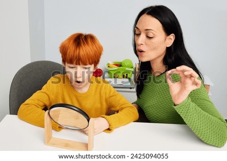 Pediatric speech-language pathologist work with handsome boy to improve articulation, decrease stuttering