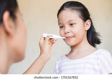 pediatrician or doctor checks elementary age asia little girl body temperature with thermometer in mouth for virus symptom. healthcare and medicine. epidemic coronavirus (2019-nCoV) outbreak concept - Powered by Shutterstock