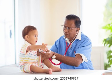 Pediatrician doctor examining baby. Asian boy in health clinic for test and screening. Infant vaccination. Kids treatment and check up. Health care for kids. Infant routine exam and vaccine shot. - Powered by Shutterstock