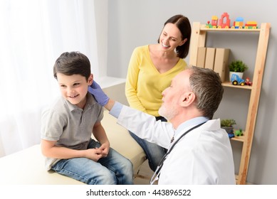 Pediatrician doctor examining child - Powered by Shutterstock