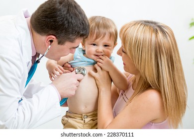 Pediatrician Doctor Examining Child. Mother Holding Baby In Her Hands.