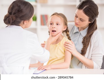 Pediatrician Doctor Examining Child. Mother Holding Baby In Her Hands.