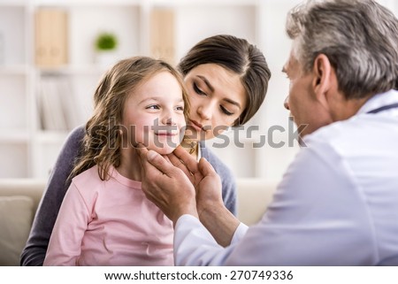 Pediatrician doctor examining child. Mother holding baby in her hands.