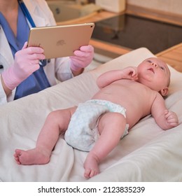 Pediatrician Doctor Holding Apple Ipad And Newborn Baby. Nurse In Uniform With Baby And Digital Tablet - Moscow, Russia, August 17, 2021