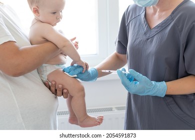 Pediatrician Doctor With Syringe, Tense Mother And Baby