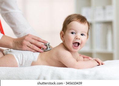 Pediatrician Examining Baby Boy. Doctor Using Stethoscope To Listen To Kid Back Checking Heart Beat. 