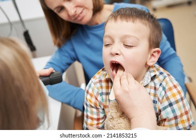 Pediatrician Examining Child Throat With Tongue Depressor