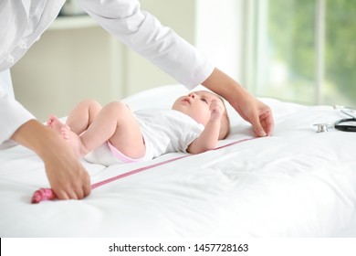 Pediatrician Examining Little Baby In Clinic