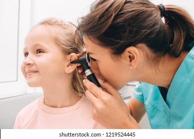 Pediatrician Examining Little Patient With Otoscope, Hearing Exam Of Child