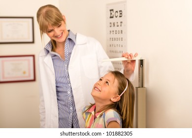 Pediatrician Measure Height Of Little Girl At Medical Office