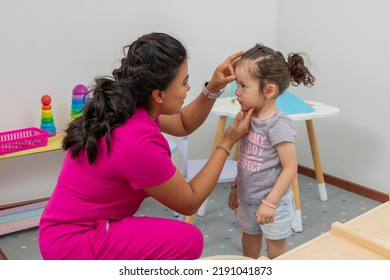 Pediatrician Rewards A Girl Who Is In His Office, Placing A Star Of Good Conduct On Her Forehead