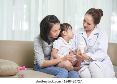 Pediatrician showing prescribed medicine mother and her little daughter - Powered by Shutterstock