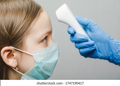 Pediatrician Using Infrared Forehead Thermometer (thermometer Gun) To Check Little Girl's Body Temperature - Screening For Virus Symptoms Concept