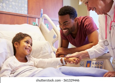 Pediatrician Visiting Father And Child In Hospital Bed