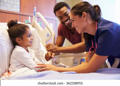 Pediatrician Visiting Father And Child In Hospital Bed