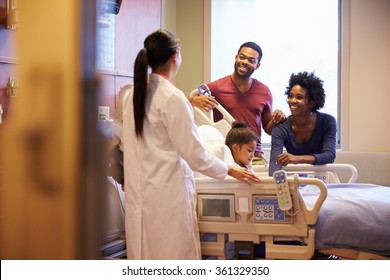 Pediatrician Visiting Parents And Child In Hospital Bed