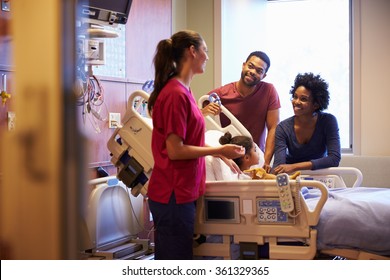 Pediatrician Visiting Parents And Child In Hospital Bed