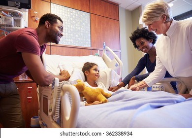 Pediatrician Visiting Parents And Child In Hospital Bed