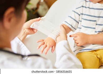 Pediatrician wraps bandage around child's wrist in the event of a sprain or accident - Powered by Shutterstock