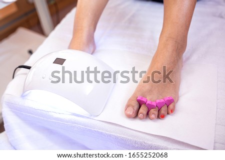 Pedicure concept with uv toenail drying, uv light nail polish drying on the toenails