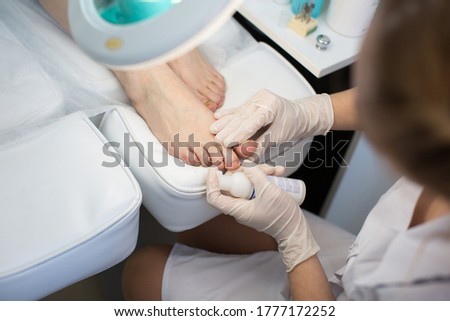 Pedicure dead skin remover foot rasp woman in nail salon. Application of the cream