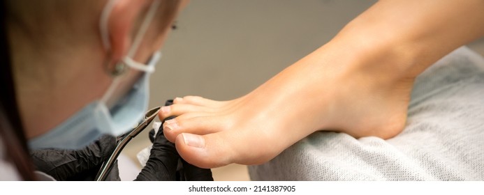 Pedicure Master Using Nail Nippers While Trimming Toenails In A Pedicure Salon.