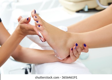 Pedicure moisturizing cram after dead skin remover foot rasp woman in nail salon