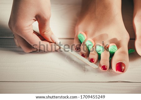 Pedicure in a professional beauty salon. Toe separators during nail files. Advertising photo for manicure salon.