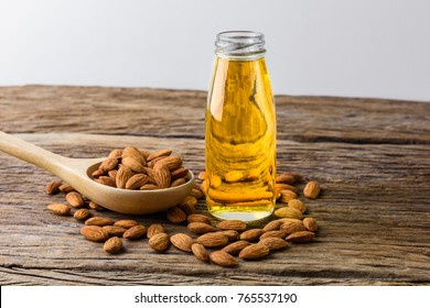 Peeled almonds with bowl and Bottle of almond oil on rustic wooden background