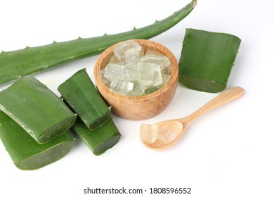 Peeled aloe vera is placed in a wooden cup on a white background.