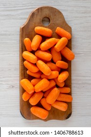 Peeled Baby Carrots On A Rustic Wooden Board Over White Wooden Background, Top View. Overhead, From Above, Flat Lay. 