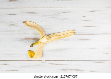 Peeled banana on a light wooden background. A bitten banana.