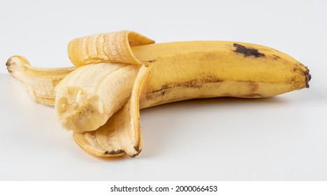 A peeled and bitten banana in a peel on a white background. Old one peeled banana. Tropical yellow fruit. Selective focus. Bitten Banana.