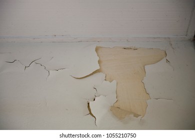 Peeled and cracked white paint on a wall - Shutterstock ID 1055210750