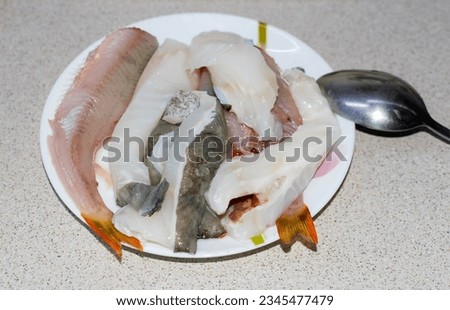 Peeled fresh fish on a plate on the table. Perch and catfish